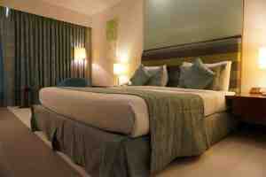 Hotel room with a made bed and bedside lamps