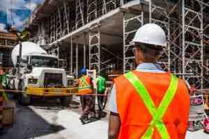 Construction worker in a hard hat and safety vest on a job site